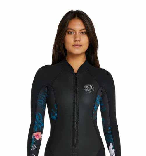 Woman wearing a black O’Neill long-sleeve front-zip wetsuit with blue tropical print panels